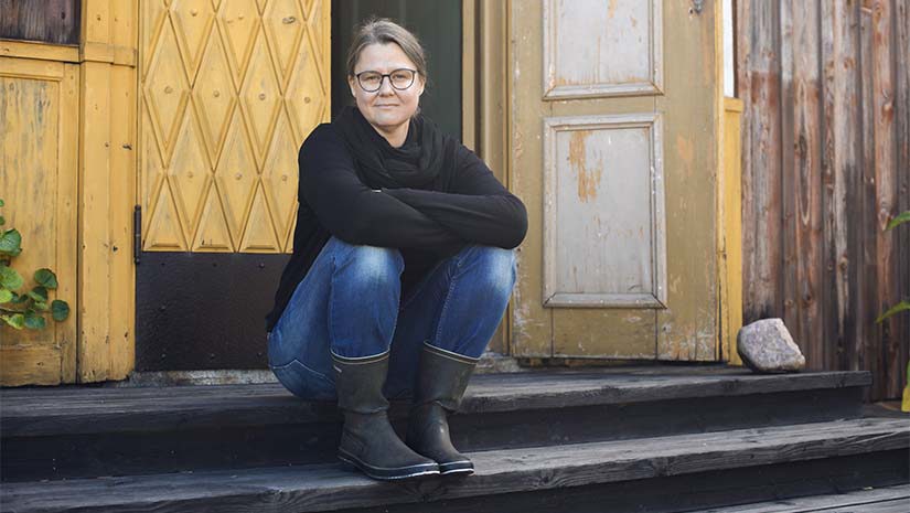 Kristina Levén sittande utanför sitt hus. 