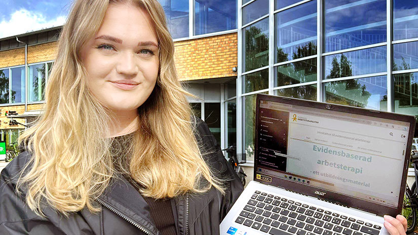 Leonella Ahlén står utanför Umeå universitet och håller upp en dator som visar kursen Evidensbaserad arbetsterapi. 